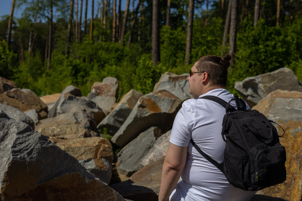 背包客在森林的岩石上休息。