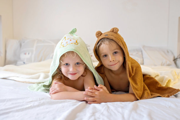 男孩和女孩在卧室的毯子下玩得很开心。