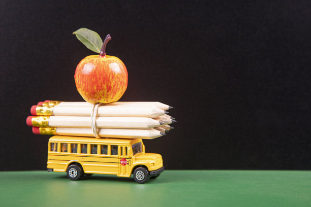 学校用品和木制桌子上的苹果