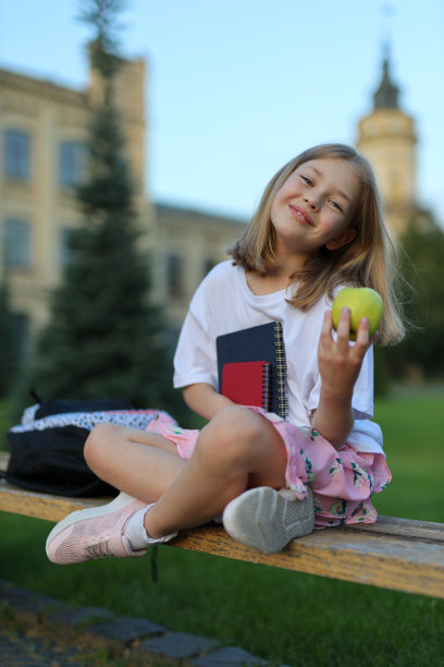 拿着苹果和书的小女孩
