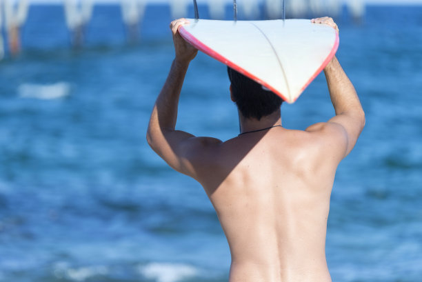 男人拿着冲浪板的背影