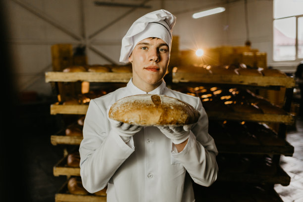 展示一个新鲜面包的面包师