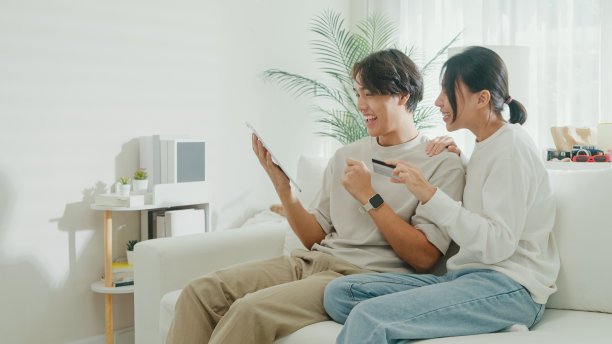 幸福的夫妻在沙发上使用平板电脑