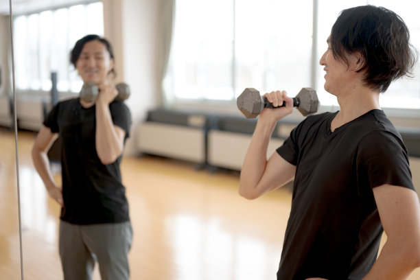 健美男子在健身俱乐部或健身房练习举重哑铃