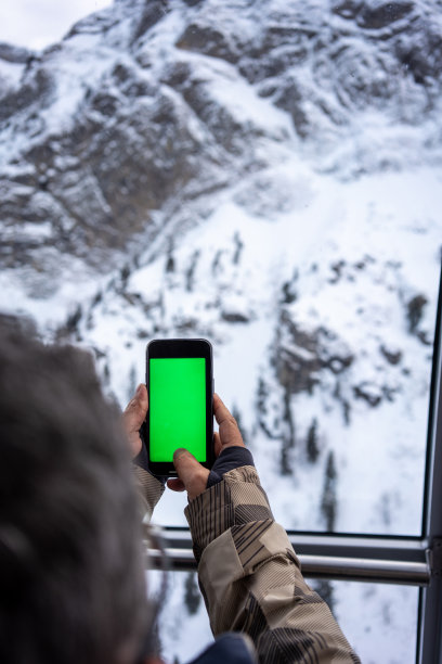 手持手机拍摄山间风景