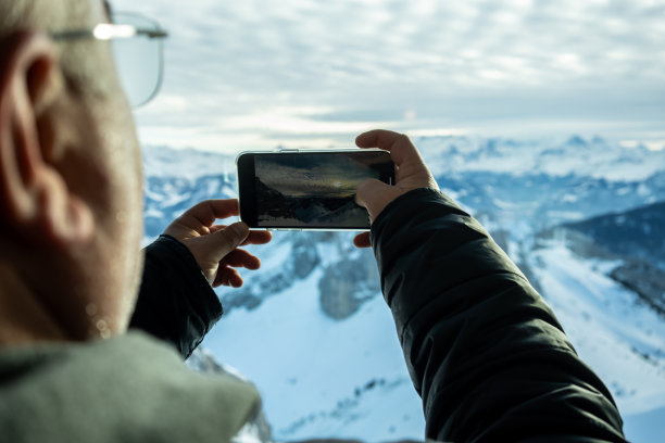 手持手机拍摄山间风景
