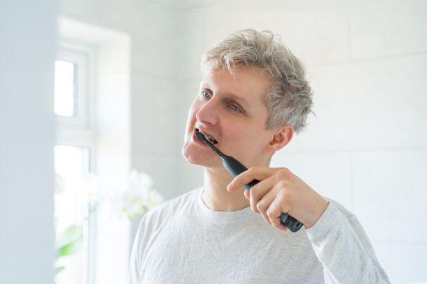 年轻男士用电动牙刷刷牙