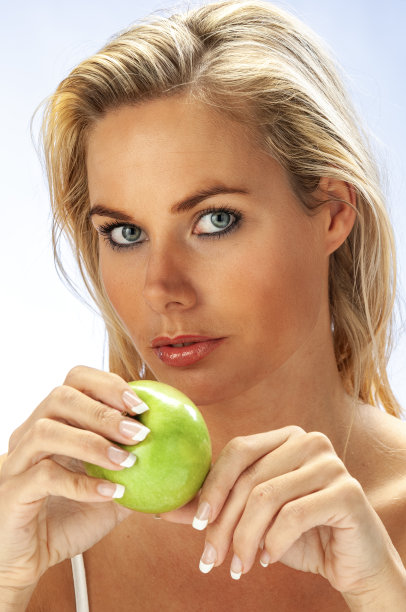 年轻女子拿着一个绿色的苹果