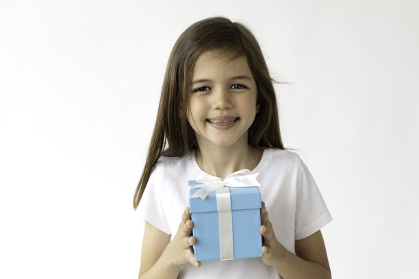 在白色背景上，手持礼品盒的美丽女孩的肖像