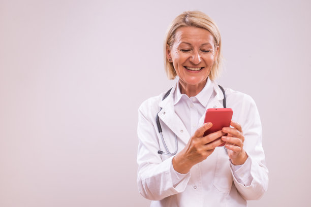 微笑的女医生在医院使用手机