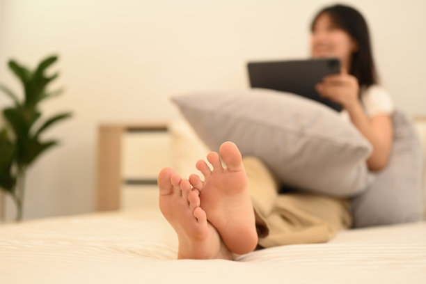 女人在床上使用平板电脑