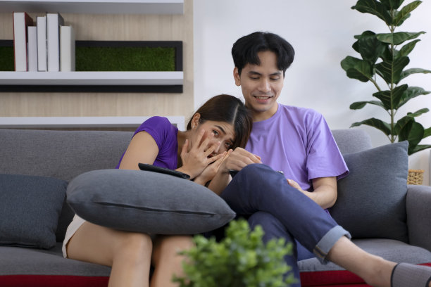 幸福的夫妻在沙发上使用平板电脑