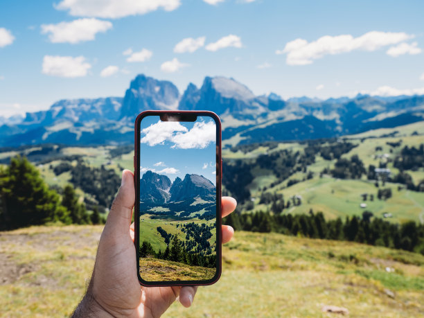 手持手机拍摄山间风景