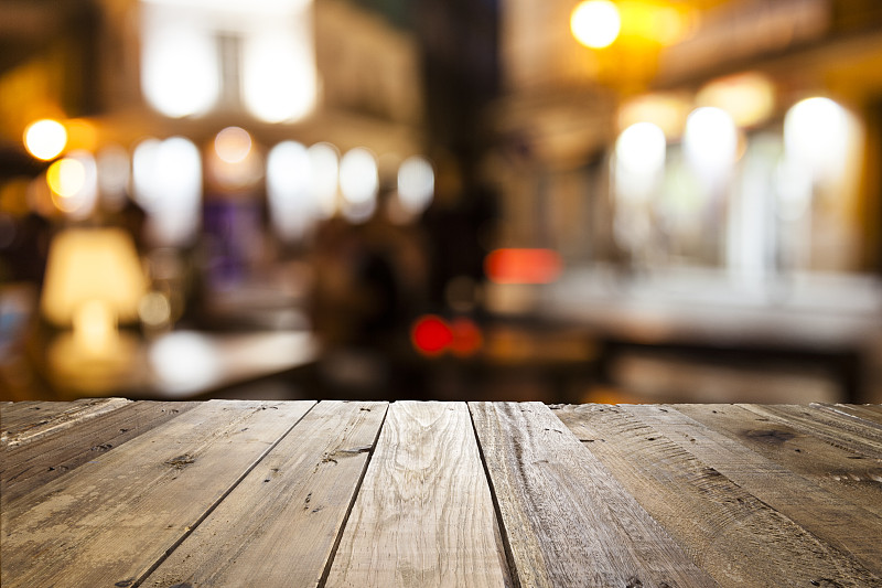 Empty,wooden,table,with,defocused,street,café,at,background
