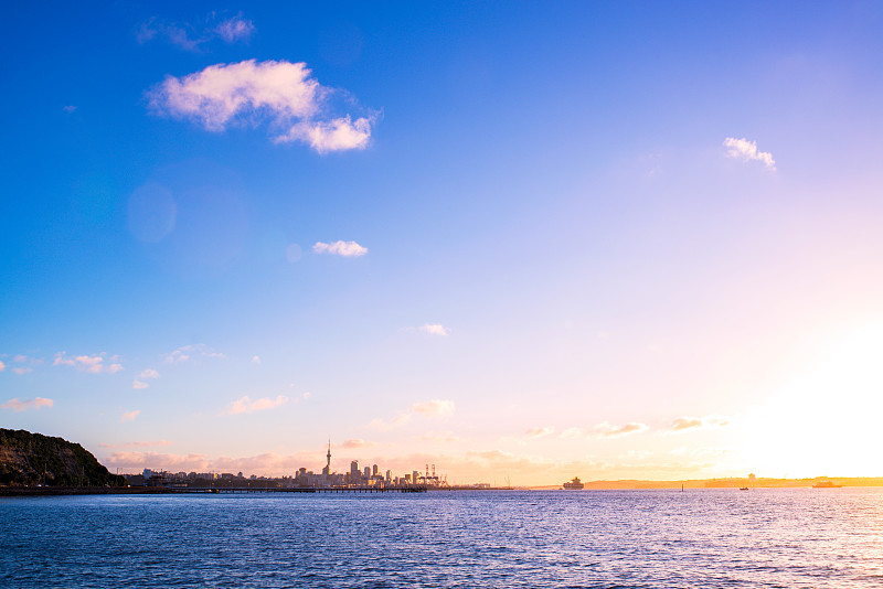 sunset,above,Auckland,city’s,skyline,with,the,ocean,at,the,front